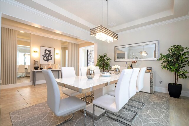 tiled dining area featuring ornamental molding and a raised ceiling