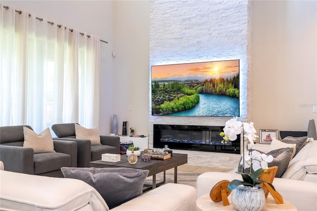 living room featuring light tile patterned flooring and a stone fireplace