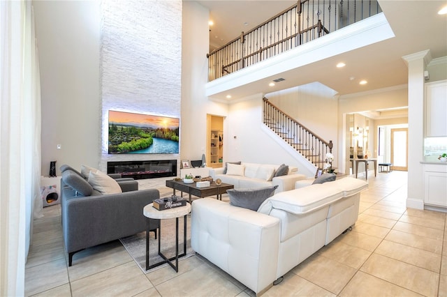 tiled living room featuring a high ceiling, a fireplace, and crown molding