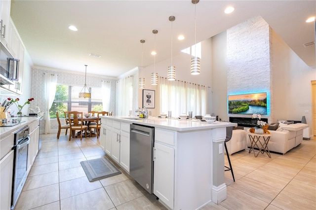 kitchen featuring white cabinetry, a wealth of natural light, a center island with sink, and stainless steel appliances