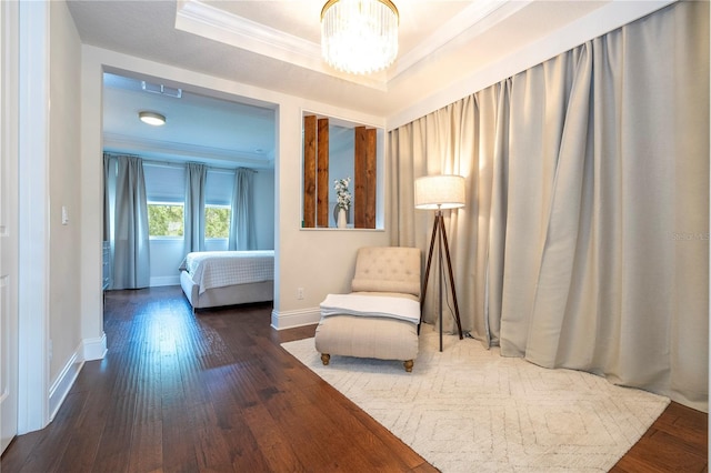 sitting room featuring ornamental molding, hardwood / wood-style floors, a chandelier, and a tray ceiling