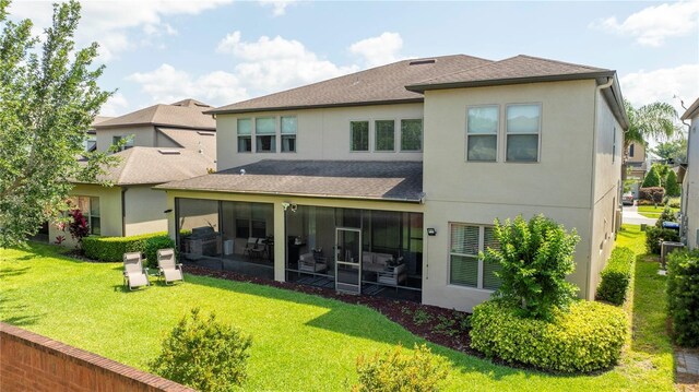 back of house with a yard and a sunroom