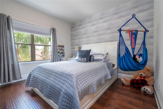 bedroom with wooden walls and hardwood / wood-style floors