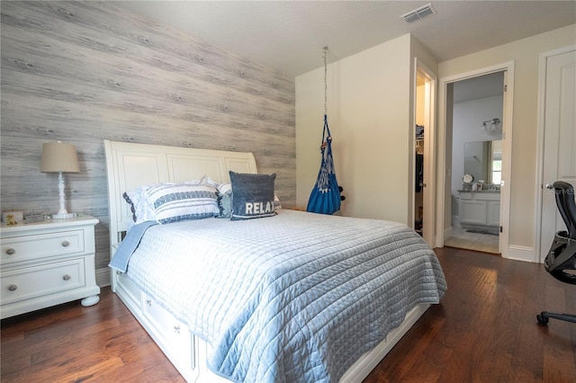 bedroom featuring hardwood / wood-style flooring and connected bathroom