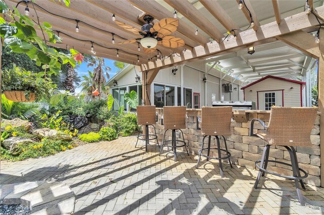 view of patio featuring a bar, ceiling fan, and area for grilling