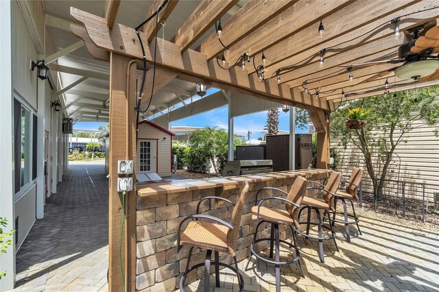 view of patio featuring an outbuilding, an outdoor bar, and ceiling fan