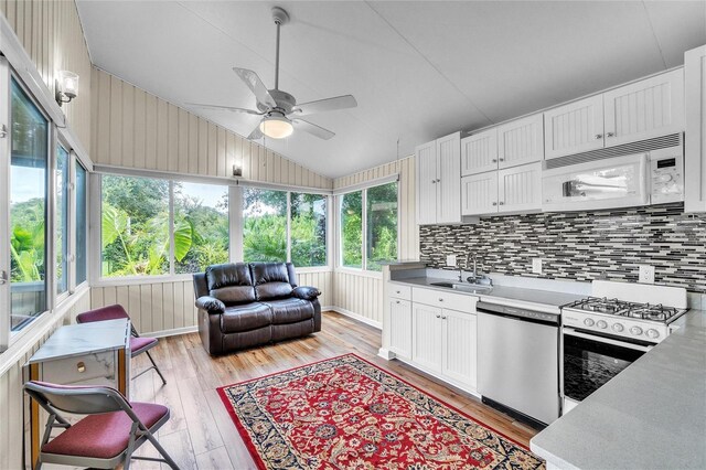 kitchen featuring white cabinetry, lofted ceiling, white appliances, ceiling fan, and light hardwood / wood-style floors