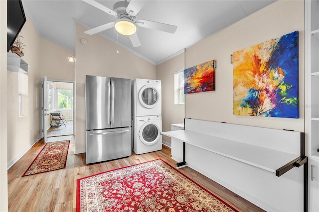 interior space with stacked washing maching and dryer, light hardwood / wood-style flooring, ceiling fan, and ornamental molding