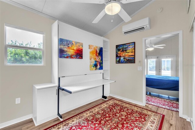 interior space featuring a wall mounted air conditioner, light hardwood / wood-style flooring, vaulted ceiling, and ornamental molding