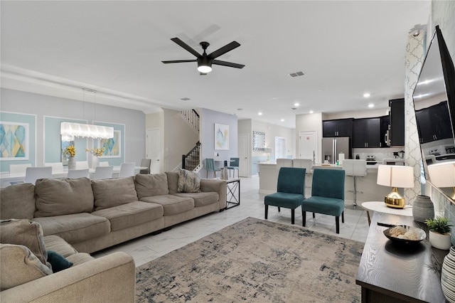 living room featuring ceiling fan with notable chandelier