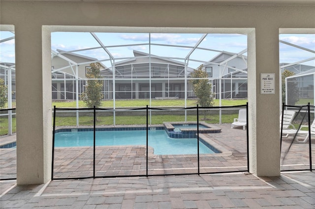 view of pool with an in ground hot tub, glass enclosure, and a patio area