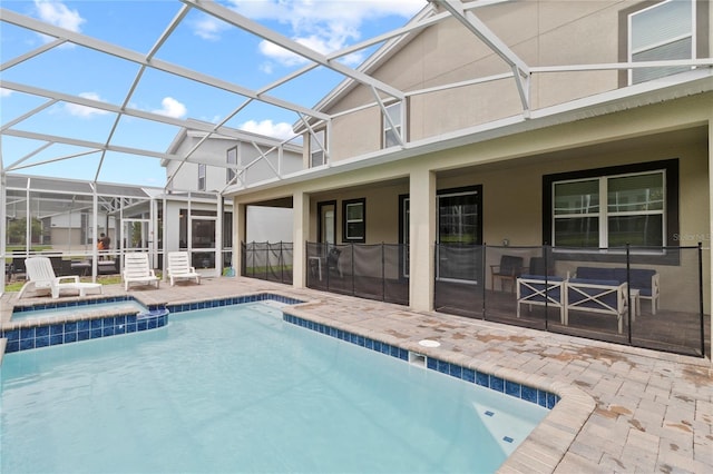 view of pool with an in ground hot tub, a patio, and glass enclosure