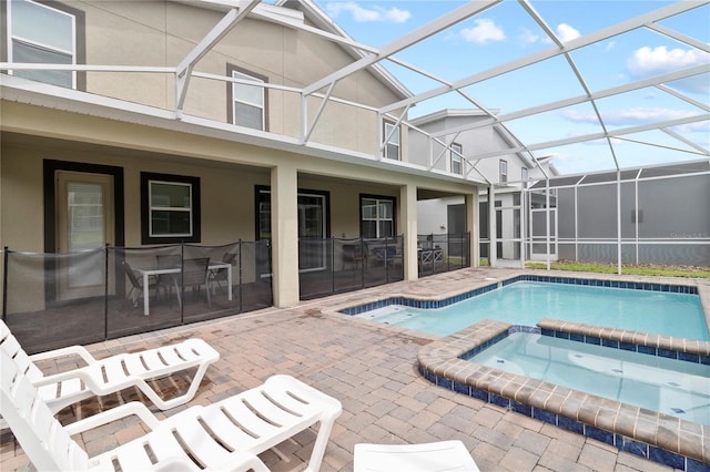 view of swimming pool featuring an in ground hot tub, a patio, and glass enclosure