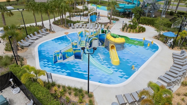 view of swimming pool with a playground and a water slide