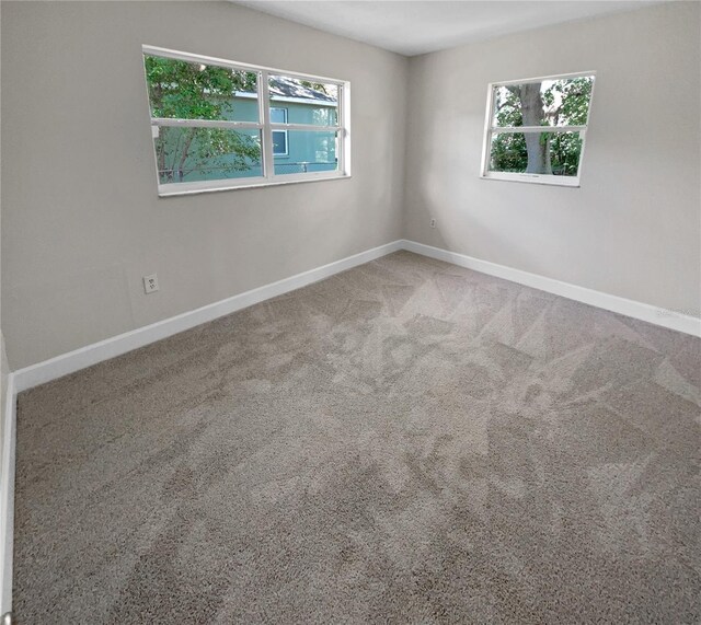 carpeted empty room with plenty of natural light