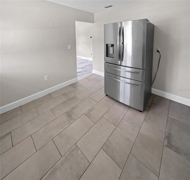 kitchen featuring stainless steel fridge and light tile patterned flooring