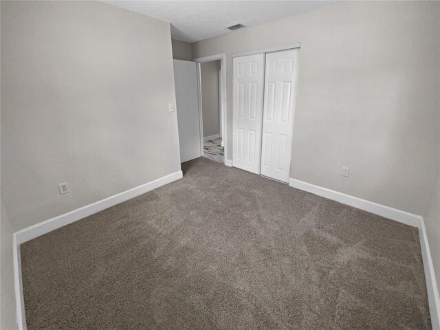 unfurnished bedroom featuring a closet and carpet flooring