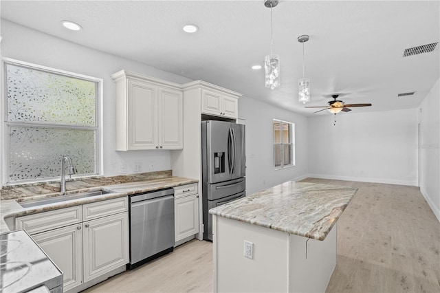 kitchen with plenty of natural light, stainless steel appliances, sink, and ceiling fan