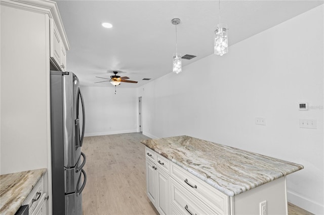 kitchen featuring stainless steel fridge, decorative light fixtures, light hardwood / wood-style floors, and ceiling fan