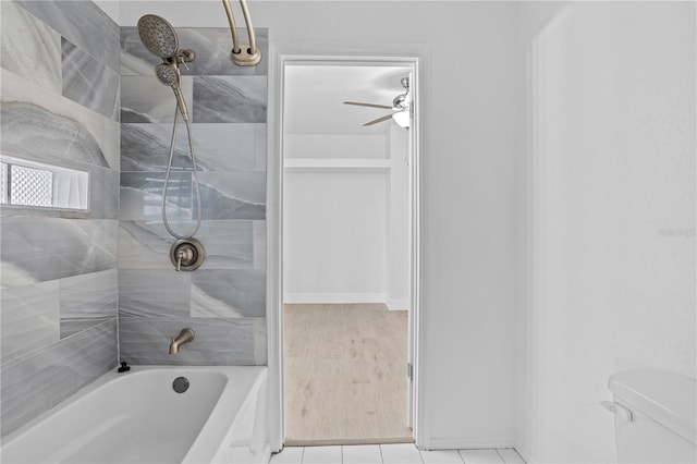 bathroom featuring toilet, wood-type flooring, tiled shower / bath, and ceiling fan