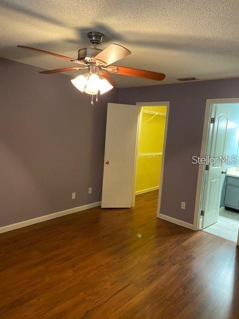 unfurnished room featuring visible vents, baseboards, and wood finished floors