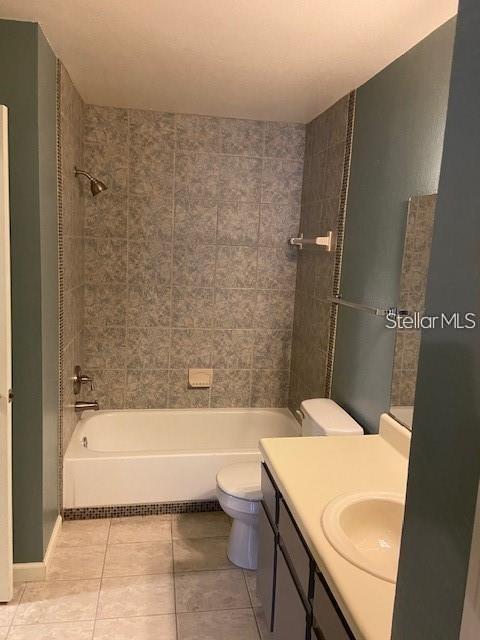 bathroom with toilet, tile patterned flooring, tub / shower combination, and vanity