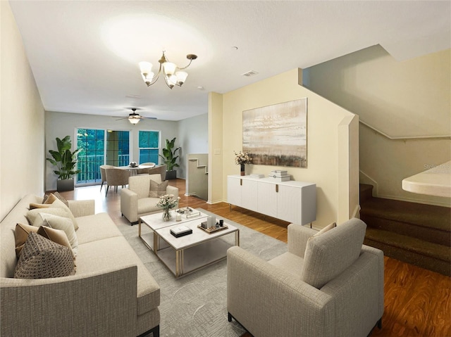 living room featuring ceiling fan with notable chandelier and wood-type flooring