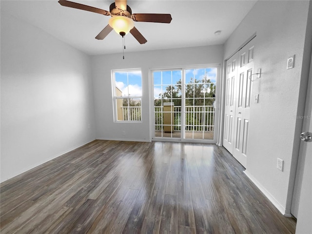 spare room with dark wood-type flooring and ceiling fan