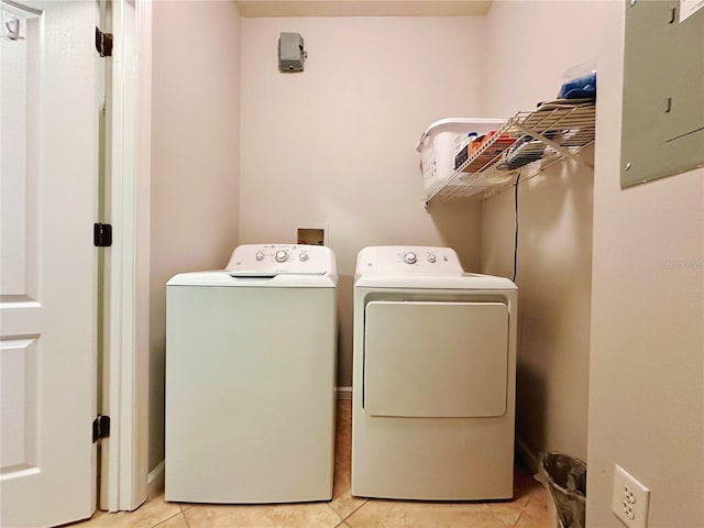 clothes washing area featuring separate washer and dryer, light tile patterned floors, and electric panel