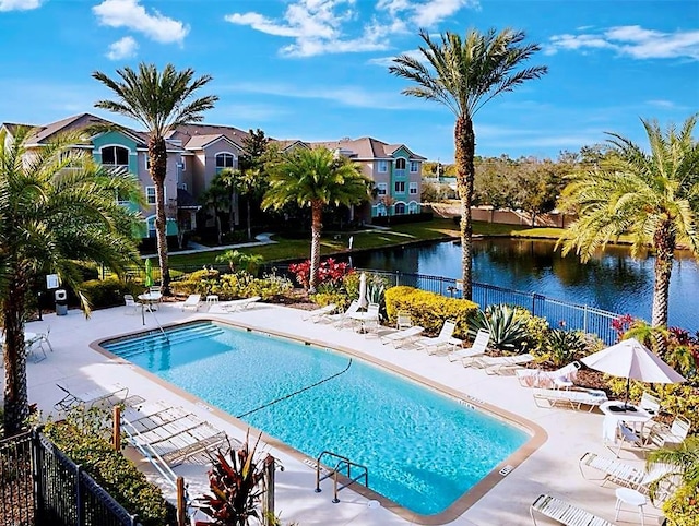 view of swimming pool featuring a water view and a patio area