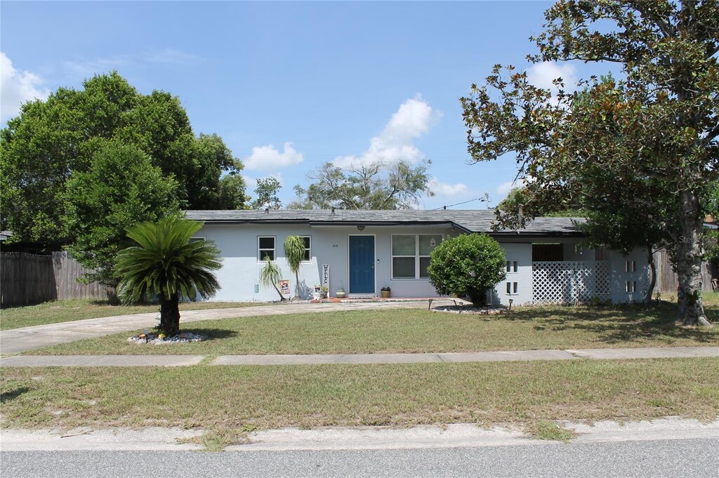 513 Elm Dr, Casselberry, FL 32707 - view of front facade featuring a front lawn, fence, and stucco siding