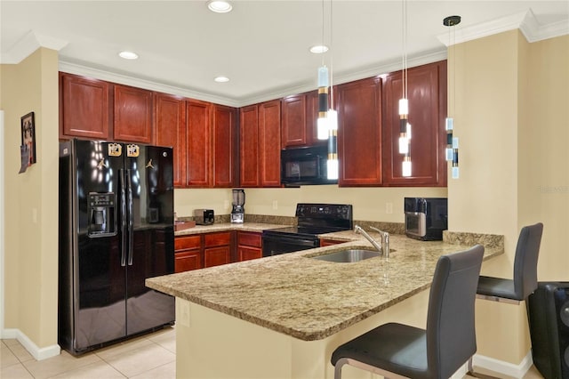 kitchen featuring kitchen peninsula, light stone counters, black appliances, decorative light fixtures, and sink