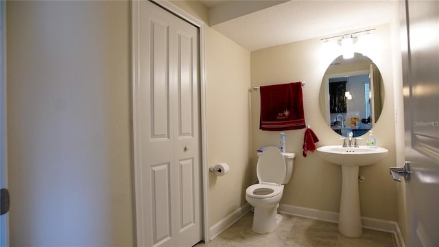 bathroom featuring a textured ceiling, toilet, and tile patterned floors