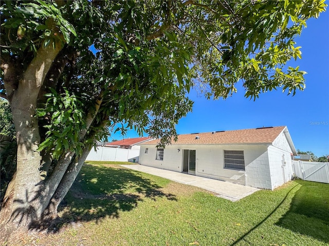 back of property featuring a patio area and a yard