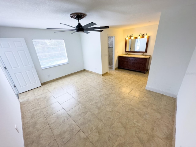 unfurnished bedroom featuring ceiling fan, sink, and a textured ceiling