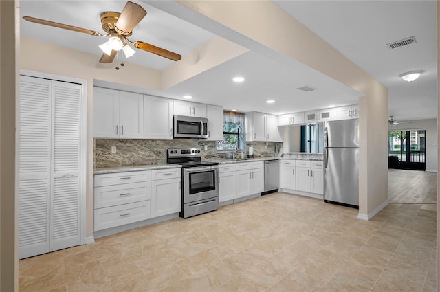 kitchen featuring white cabinetry, a healthy amount of sunlight, ceiling fan, and stainless steel appliances