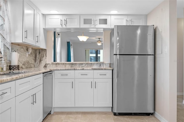 kitchen with decorative backsplash, ceiling fan, stainless steel appliances, and white cabinets