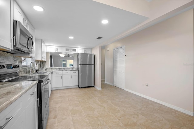 kitchen with white cabinets, tasteful backsplash, light tile patterned flooring, and appliances with stainless steel finishes