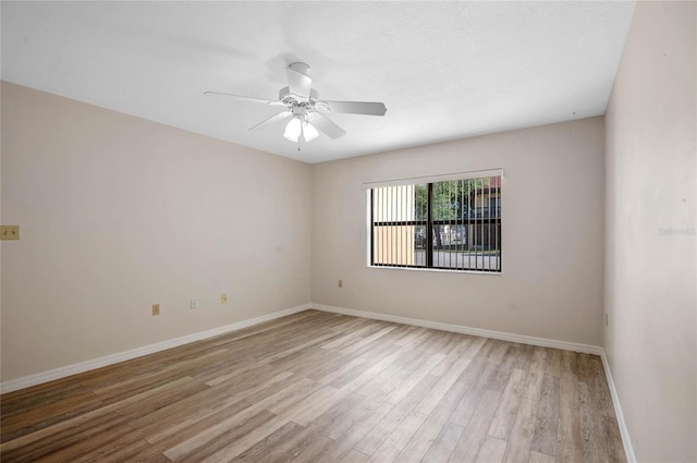 empty room with ceiling fan and light hardwood / wood-style floors