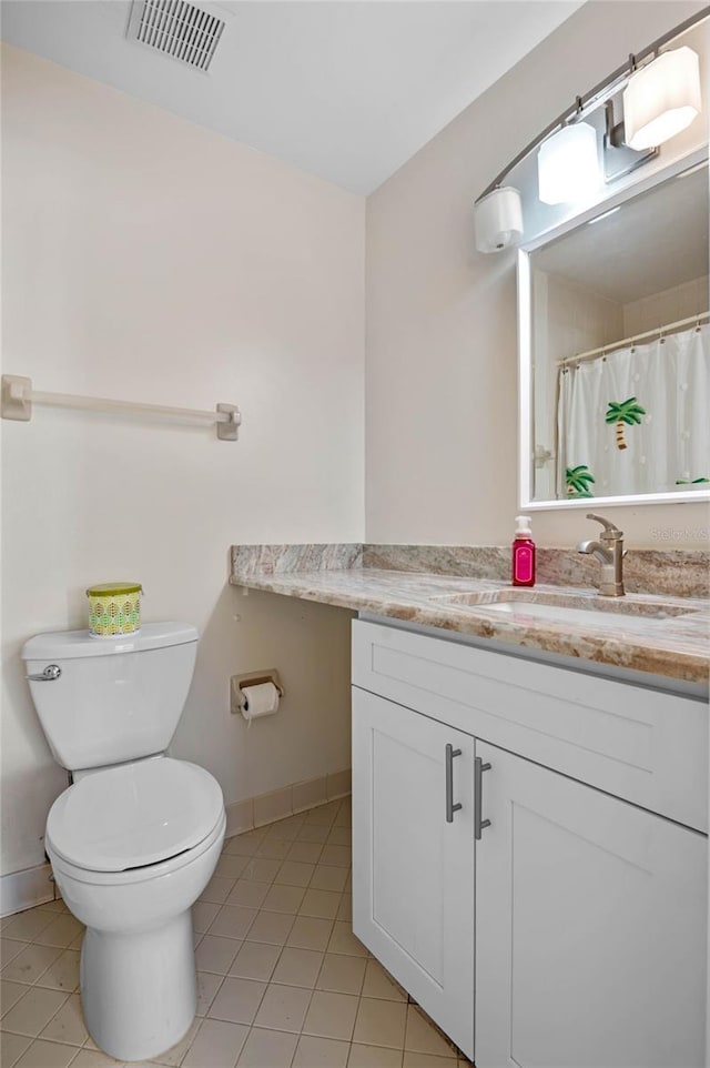 bathroom featuring tile patterned flooring, toilet, and vanity