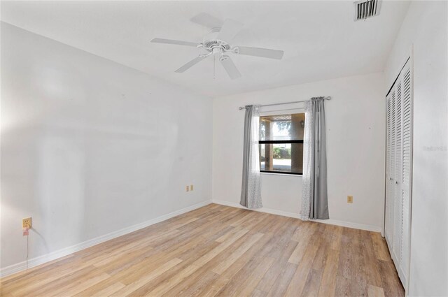 spare room with ceiling fan and light wood-type flooring