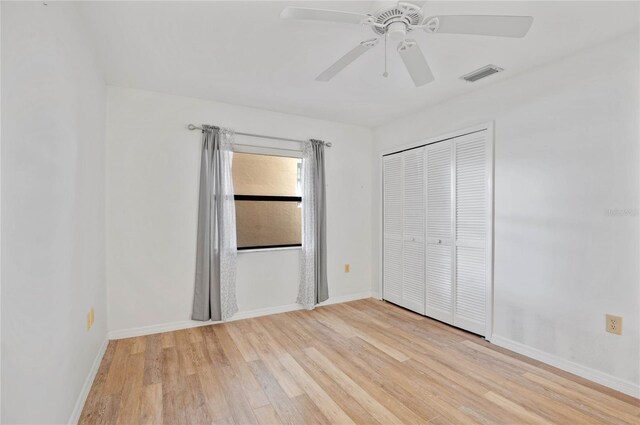 unfurnished bedroom with light hardwood / wood-style flooring, a closet, and ceiling fan