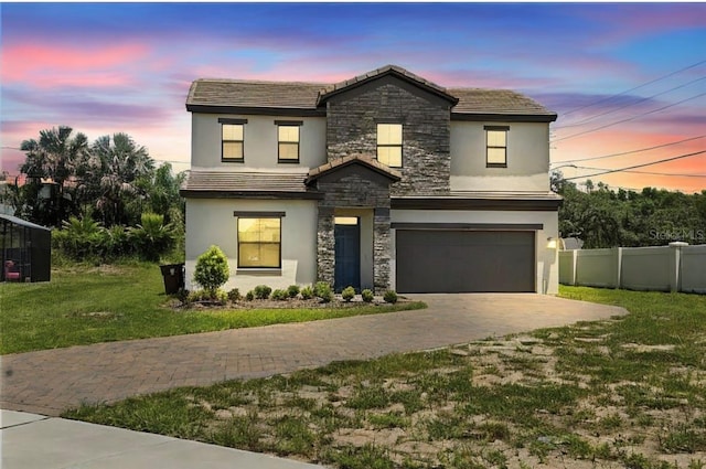 view of front of home with a garage and a lawn