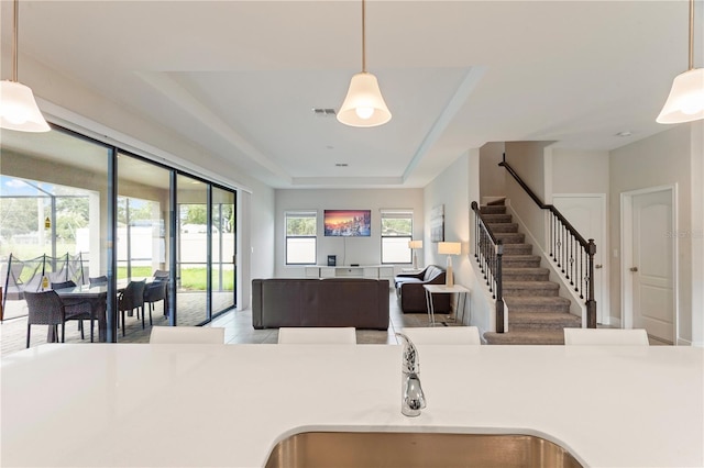 kitchen with sink, pendant lighting, and a raised ceiling