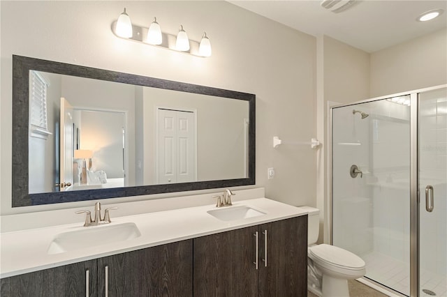 bathroom with a shower with shower door, toilet, and vanity