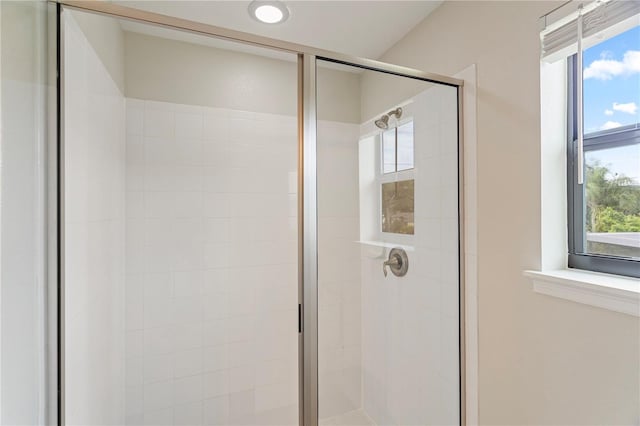 bathroom with a shower with door and a healthy amount of sunlight