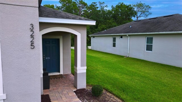 doorway to property with a lawn