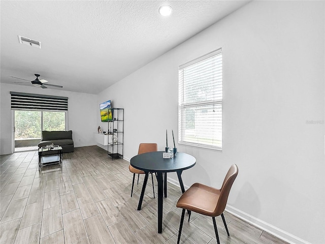 dining space with a textured ceiling and ceiling fan