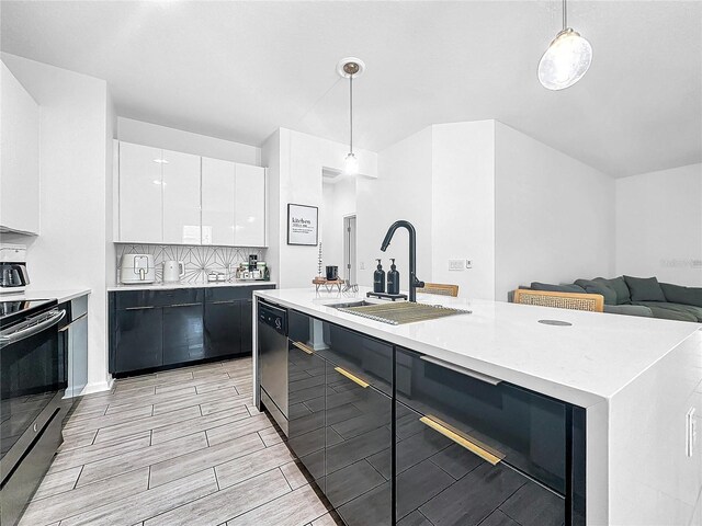 kitchen with white cabinetry, stainless steel appliances, decorative backsplash, decorative light fixtures, and sink