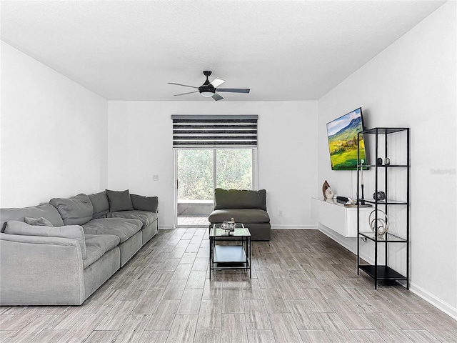 living room featuring a textured ceiling and ceiling fan